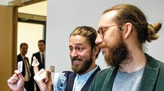 <p>Die Einhorn-Geschäftsführer Waldemar Zeiler (rechts) und Philip Siefer halten im Gericht Kondome ihrer Firma in die Kamera eines Fotografen.</p>