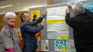 <p>Lilo Frenkel, Bürgermeister Höfer und Roland Dubberke (v.l.) hängen ein Plakat mit dem Text der Allgemeinen Erklärung der Menschenrechte auf.</p>