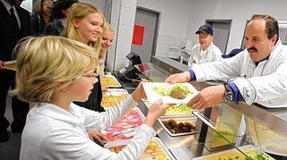 <p>Johann Lafer (r) überreicht in der Schulmensa des Gymnasiums am Römerkastell in Bad Kreuznach (Rheinland-Pfalz) dem kleinen Leo sein Mittagessen.</p>