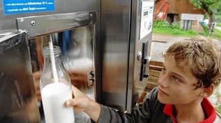 <p>Ein junge zapft Rohmilch aus einem Automaten.</p>