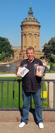 <p>Heimatverbunden: Mundart-Dichter Rainer Holzhauser vor seinem geliebten Wasserturm, in der Hand sechs Bände seiner selbstverlegten Buchserie.</p>
