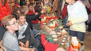 <p>Lucas Liewald (l.) und Jakob Wolf (2. v. l.) aus der Klasse 7b, die im WVR-Projektunterricht Holzsachen gebastelt hat, beraten Mitschülerin Sarah Nicolai (r.) bei ihrem Bummel durch den MRS-Adventsbasar.</p>