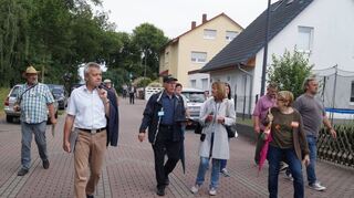 <p>Wohnen im Grünen: Auch damit versuchen die Hüttenfelder und Bürgermeister Gottfried Störmer (2.v.l.), beim Rundgang die Jury zu überzeugen.</p>