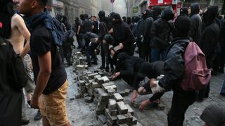 Der "Schwarze Block" stapelt während der Ausschreitungen beim G20-Gipfel in Hamburg Pflastersteine.