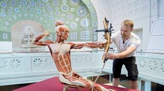 <p>Im Männerbad werden die "Körperwelten" aufgebaut. Sven Rosenberger legt dem Sportler den Bogen in die Hand.</p>