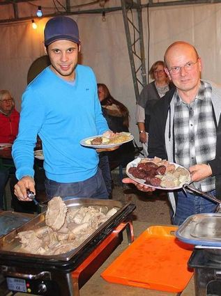 <p>Athlet Michael (l.) und ASV-Ur-Mitglied Jakob Hege bedienten sich beim Schlachtfest am reichhaltigen Buffet, das viele Fleischgerichte bot.</p>