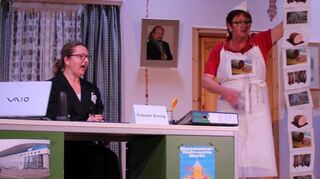 Die Metzgerin (r. Jutta Preißendörfer) beschwert sich bei Emsig (l. Viola Doll) über die gestohlene Premiumwurst.