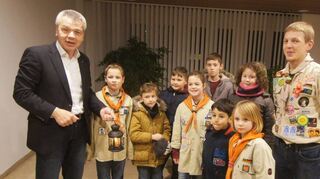 Bürgermeister Gottfried Störmer (links) freut sich über den Besuch der Wölflinge, die ihm in Begleitung ihres Leiters Tim Siegel das Friedenslicht vorbeibringen.