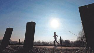 Eine Frau läuft am frühen Morgen auf einem Feldweg bei Hannover an Bahnschwellen vorbei. Mehr Sport: ein Klassiker unter den guten Vorsätzen für das neue Jahr, die dann doch oft scheitern – und unzufrieden machen.