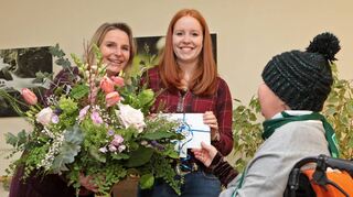 Sarah Hofmann (M.) – die strahlende Gewinnerin. „MM“-Redakteurin Angela Boll (l.) und eine Bewohnerin von St. Vincent überreichen Blumen und Gutschein.