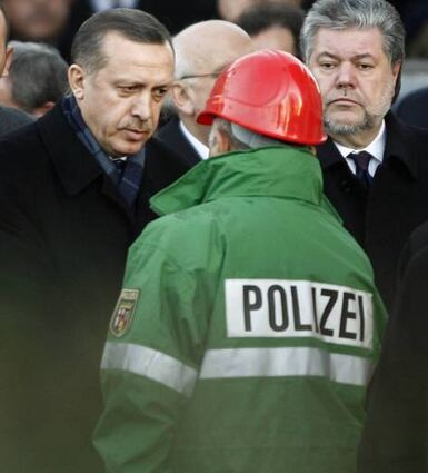 Recep Tayyip Erdogan (l.) und der damalige Ministerpräsident Kurt Beck (r.) sprechen mit Einsatzkräften.