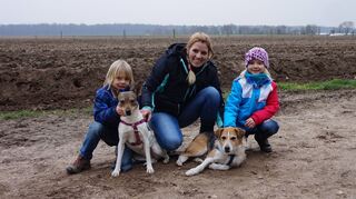Alles wieder gut (v.l.): Luke, Melanie und Lucie Eicher mit den Hündinnen Hilde (l.) und Jacky. In dem Feld hinter ihnen fraß Jacky den Giftköder.