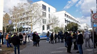 Vor dem Gebäude der Karolina-Burger-Realschule plus in Mundenheim haben sich viele besorgte Eltern und Mitschüler versammelt.