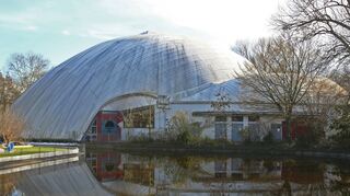 Größte frei tragende Dachkonstruktion der Welt: die Multihalle, hier die Nordansicht vom Bereich des Wasserspielplatzes aus. Die Außenhaut ist beschädigt.