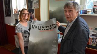 Kirsten Kieninger (links) aus dem Programmrat des Karlstorkinos und Regisseur Thomas Frickel mit dem Plakat zu „Wunder der Wirklichkeit“.