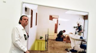 Der Meister und sein Werk: Jeff Wall spricht über das im Zentrum der Schau stehende „Search Of Premises“ (Hausdurchsuchung), auf dem Beamte nach Indizien suchen – wonach genau, bleibt unklar.