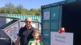 Luca (l.) und Marco Fichera entsorgen ihre Wertstoffe auf dem Hof, hier bringen sie ein altes Fernsehgerät in den dafür vorgesehenen Container.