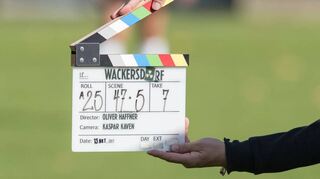 Ein Mitarbeiter des Teams zum Film „Wackersdorf“ hält am Set zu den Dreharbeiten eine Filmklappe in die Kamera. Auch beim Ilvesheimer Ferienprogramm kommt die Klappe zum Einsatz.