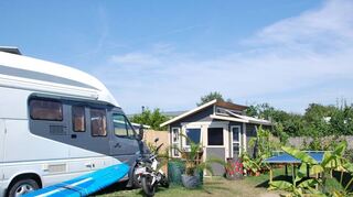 Revier für Wassersportler: Boote oder Surfbretter stehen vor nahezu jedem Häuschen oder Wohnmobil in der Freizeitanlage.