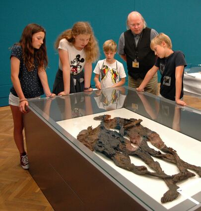 In der Mumien-Ausstellung (v.l.): Sarah, Hannah, Yannick und Lennard von der Mumien-AG des Ludwig-Frank-Gymnasiums mit Direktor Wilfried Rosendahl von den Reiss-Engelhorn-Museen vor einer Vitrine mit Moorleichen.