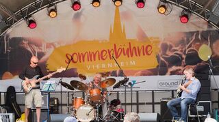 Das Michael Sagmeister-Trio heizt den Zuhörern vor der Sommerbühne beim Morgen-Jazz auf dem Viernheimer Rovigoplatz tüchtig ein. Unter ihnen sind Dr. Heijo Kneuper und Yvonne Obrowski aus Mannheim (kleines Bild oben). Michael Sagmeister spielt meistens mit geschlossenen Augen (kleines Bild unten).