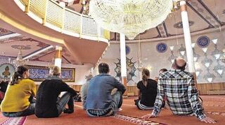 Besucher sitzen in Mannheim in der Yavuz-Sultan-Selim-Moschee. Ob der Islam zu Deutschland gehört, ist eine immer wieder kontrovers geführte Debatte.