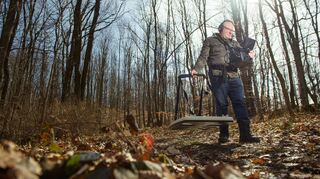 Piotr Koper geht mit einem Metalldetektor durch einen Wald. Der Pole ist maßgeblich für die Suche nach dem „Goldzug“ aus der Nazi-Zeit verantwortlich.