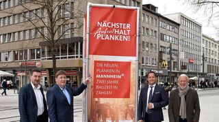 V.l. Gunnar Straßburger (RNV), Bürgermeister Lothar Quast, Florian Pavel (MVV) und Lutz Pauels (Werbegemeinschaft Mannheim City) vor einer der Stelen, die eine Ausstellung über den Umbau und zur Geschichte der Planken zeigen.