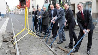 Ungewöhnlicher Spatenstich: Mit Hilfe eines Baggers hoben (v.r.) Baudezernent Klaus Dillinger, Minister Volker Wissing, RNV-Geschäftsführer Christian Volz sowie die TWL-Vorstände Thomas Mösl und Dieter Feid in der Carl-Bosch-Straße ein Gleisstück aus dem Untergrund heraus.