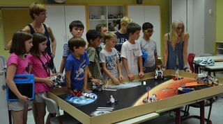 Schüler der Roboter-AG verfolgen den Einsatz ihres Roboters, der ein verunglücktes Gefährt auf die Raumstation zurückbringt.