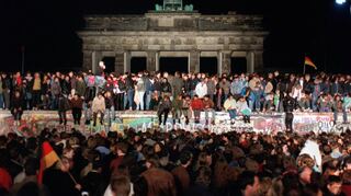 Feiernde Menschen auf der Berliner Mauer im Jahr 1989.