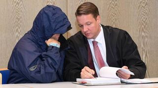 Der Angeklagte mit Regenjacke und Kapuze im Gespräch mit seinem Verteidiger Steffen Lindberg.