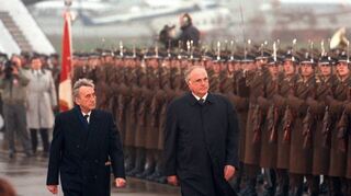 Am 9. November 1989 schreiten Bundeskanzler Helmut Kohl (r.) und der polnische Ministerpräsident Tadeusz Mazowiecki in Warschau eine Ehrenformation der polnischen Streitkräfte ab.