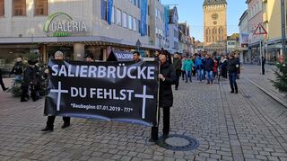 Schwarze Plakate und ein Sarg. Etwa 200 Menschen ziehen still durch die Maximilianstraße in Speyer.