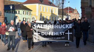 Sieben Geschäftsleute klagen gegen die Brückenbauverzögerung. Am Samstag zogen sie mit 200 Teilnehmern durch die Maximilianstraße in Speyer.
