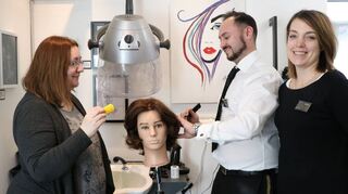 Das Team von „V.I.U.S“ übt an Puppenköpfen: v.l. Mitarbeiterin Ljiljana Petrovic, Friseurmeister Onur Ayaksiz und Initiatorin Gesine Sopha.