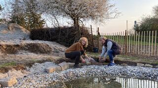 Heike Vetter (l.) und Birgit Jänicke verlegen am Rande des neuen Teichs im NABU-Garten Natursteine. Ein Molch ist hier schon eingezogen.