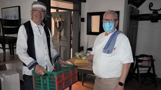 Besucher Gerhard Engländer (l.) holt sich sein Essen bei Wirt Eduard Siatkowski vom Restaurant „Zur Linde“ ab.