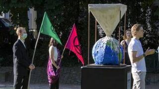 Zement fließt über die Welt: Skulptur der Umweltaktivisten.