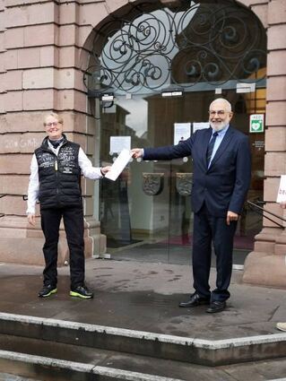 Bürgermeister Erichson überreicht Schmid-Schurig die Urkunde.
