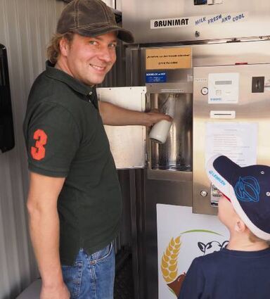 Christian Schmidt erklärt dem kleinen Florian den Milchautomaten.