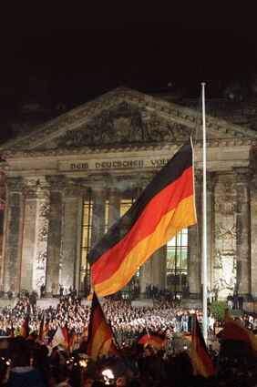 3. Oktober 1990: Die um Mitternacht gehisste Deutschlandfahne weht noch heute vor dem Reichstagsgebäude – allerdings an einem anderen Mast. Auf den Treppen standen damals Vertreter der Staatsspitze und Ehrengäste.