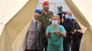 Christine Fischer vom Klinikum Ludwigshafen zeigt Stephan Schmidt, Generalstabsarzt und Kommandeur der Sanitätsdienstlichen Einsatzunterstützung (l.), und Oberst Stefan Weber, Kommandeur des Landeskommandos Rheinland-Pfalz, die Corona-Ambulanz.