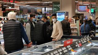 Kunden warten ohne Mindestabstand vor der Kasse im Rewe-Supermarkt in Q6/Q7.