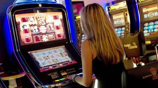 Eine Frau sitzt in Stuttgart an einem Automaten. In Baden-Württemberg              diskutieren die Parteien, ob die Regeln für Spielhallen gelockert werden.