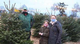 Volker Ruzek berät Ulrike Fröhner und ihre Tochter Lina beim Weihnachtsbaumkauf.