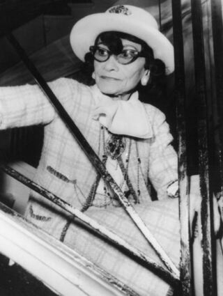 Coco Chanel verfolgt auf einer Treppe sitzend in Paris die Präsentation ihrer Frühjahr- und Sommer-Kollektion für das Jahr 1969.