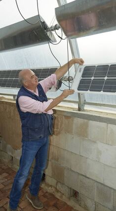 Franz Schreier zeigt, wie die flexible Photovoltaikanlage funktioniert. Auch das Gewächshaus auf dem Scheunendach soll solche Module erhalten.