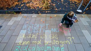 Melina Crispin, Aktivistin, schreibt mit Kreide einen anzüglichen Kommentar "#Stoppt Belästigung Ok, darf ich Sie dann mal besteigen? catcallsofmainz" auf einen Bürgersteig in der Innenstadt. Frauen aus Hessen und Rheinland-Pfalz kämpfen gegen verbale sexuelle Belästigung.