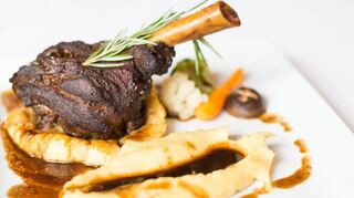 Eine Lammhaxe liegt auf Polenta.